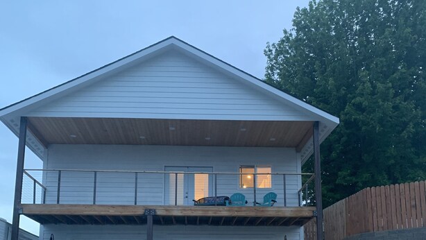 A two-story house with a garage, a balcony, and a wooden deck. - Wine Country Guest House (Kennewick)
