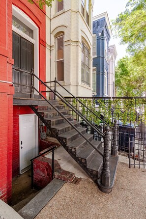 A staircase leading to a building with a red door and a white garage door.