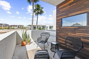 A balcony with two black wicker chairs, a small round table, and potted plants. - Pueblo Suite - Walk to all things OT Scottsdale (Scottsdale)