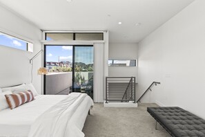 A modern bedroom with a large bed, a bench, a balcony with a view, and a small window. - Pueblo Suite - Walk to all things OT Scottsdale (Scottsdale)