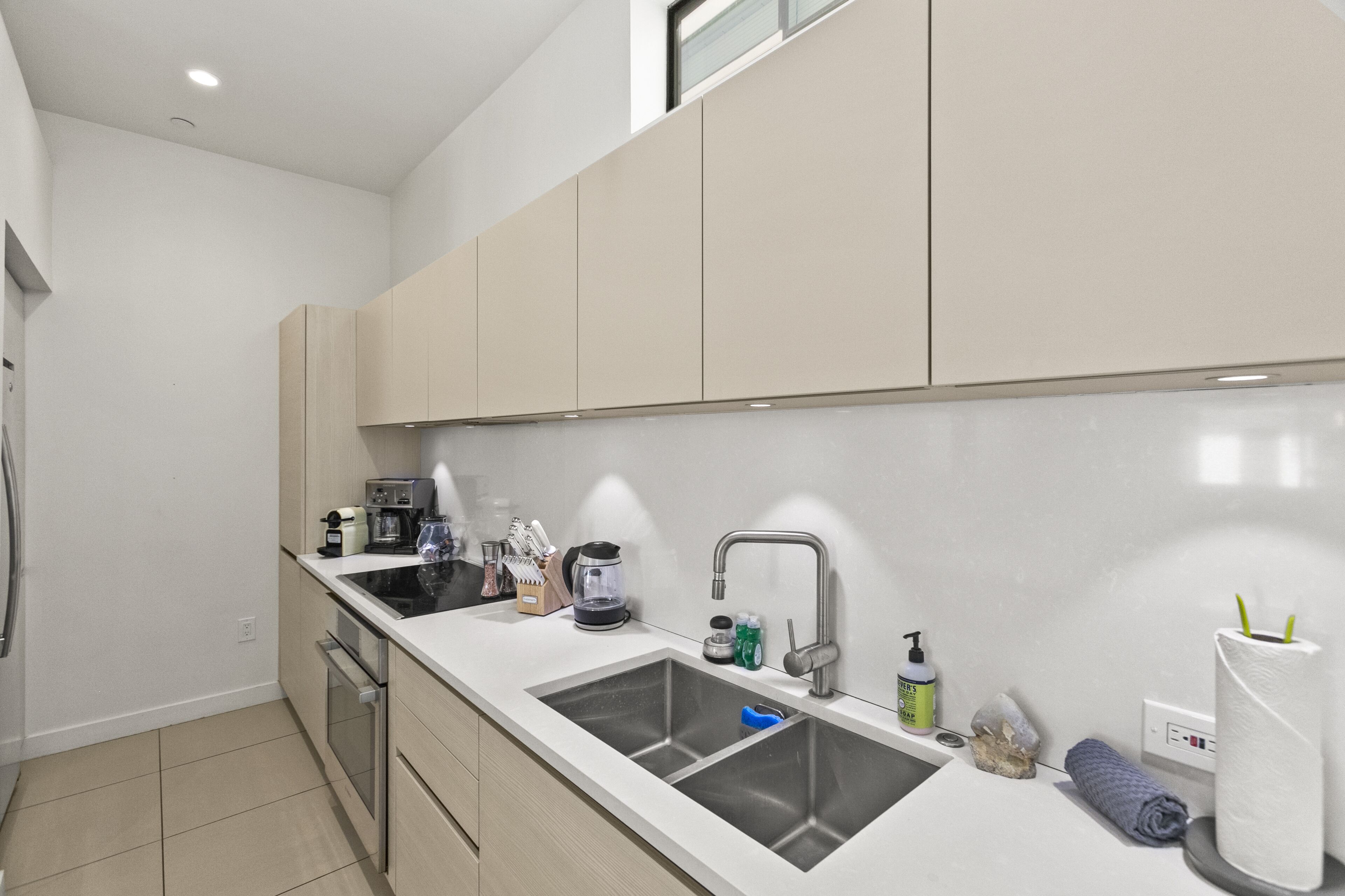 A modern kitchen with a double sink, stainless steel appliances, and a clean, minimalist design.