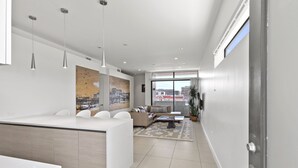 Una sala de estar moderna con sofá, mesa de centro y lámparas colgantes.
