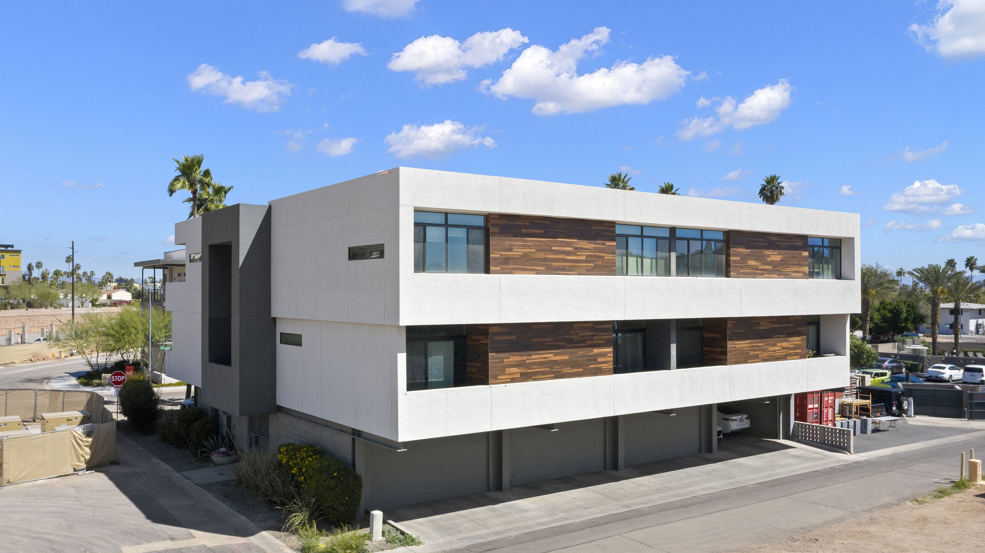 Un bâtiment moderne à deux étages, doté d’un toit plat, de grandes fenêtres et d’un mélange de béton et de panneaux de bois.