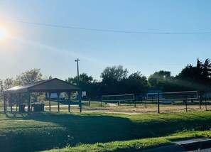 Un campo deportivo con un pabellón y una red de voleibol.
