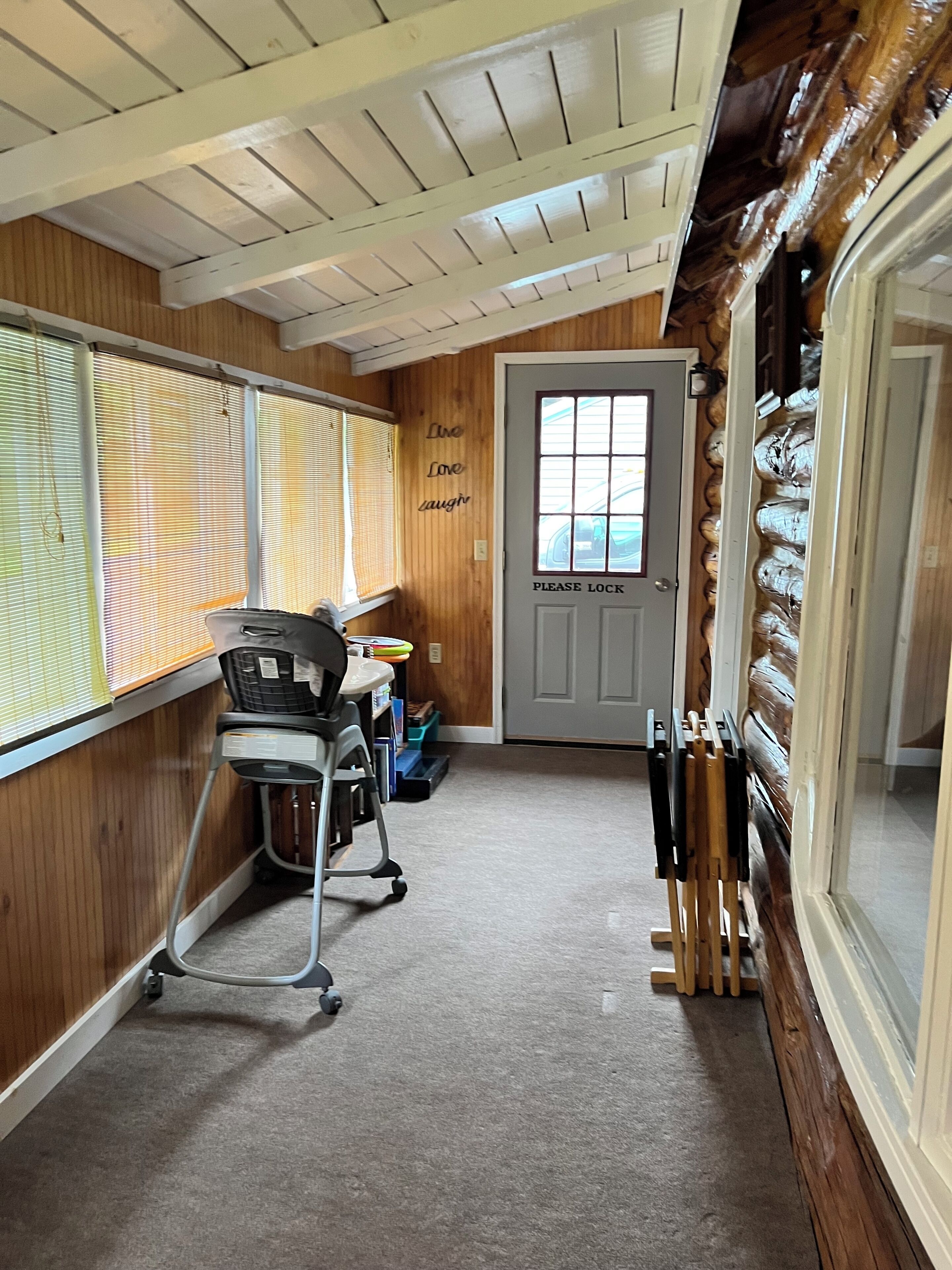 Una habitación con escritorio, silla y puerta con ventana.