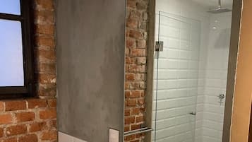 Un bany modern amb un mirall gran, un lavabo blanc i una zona de dutxa.