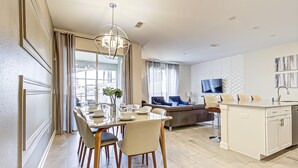 A modern kitchen with a dining area, a sofa, and a TV. - Storey Lake Resort, Private Pool, Near Famous Attractions!! (Kissimmee)