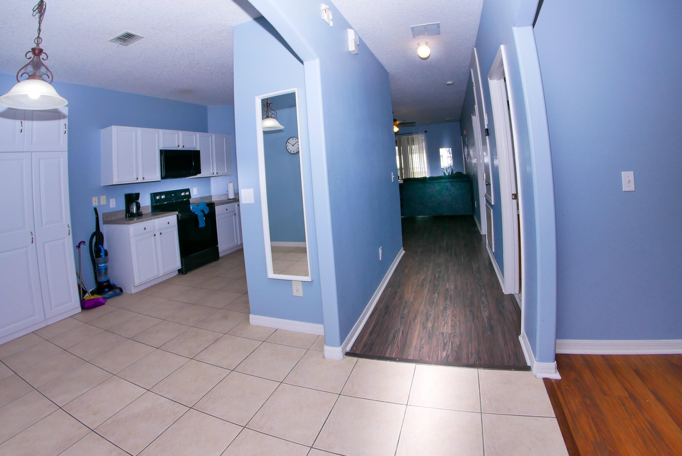 A spacious kitchen with white cabinets, a microwave, and a coffee maker.