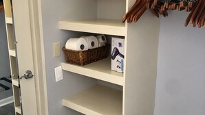 A walk-in closet with shelves, a hanging rack, and a metal drying rack. - Studio- Sleep 4,Pool, Parking,5 min walk to Beach -4 (Fort Lauderdale)
