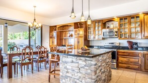 Une cuisine spacieuse dotée de meubles en bois, d’un îlot central et d’un coin repas avec des chaises.