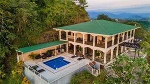 Un bâtiment à deux étages doté d’un toit végétalisé, d’une piscine et d’espaces de détente en plein air.