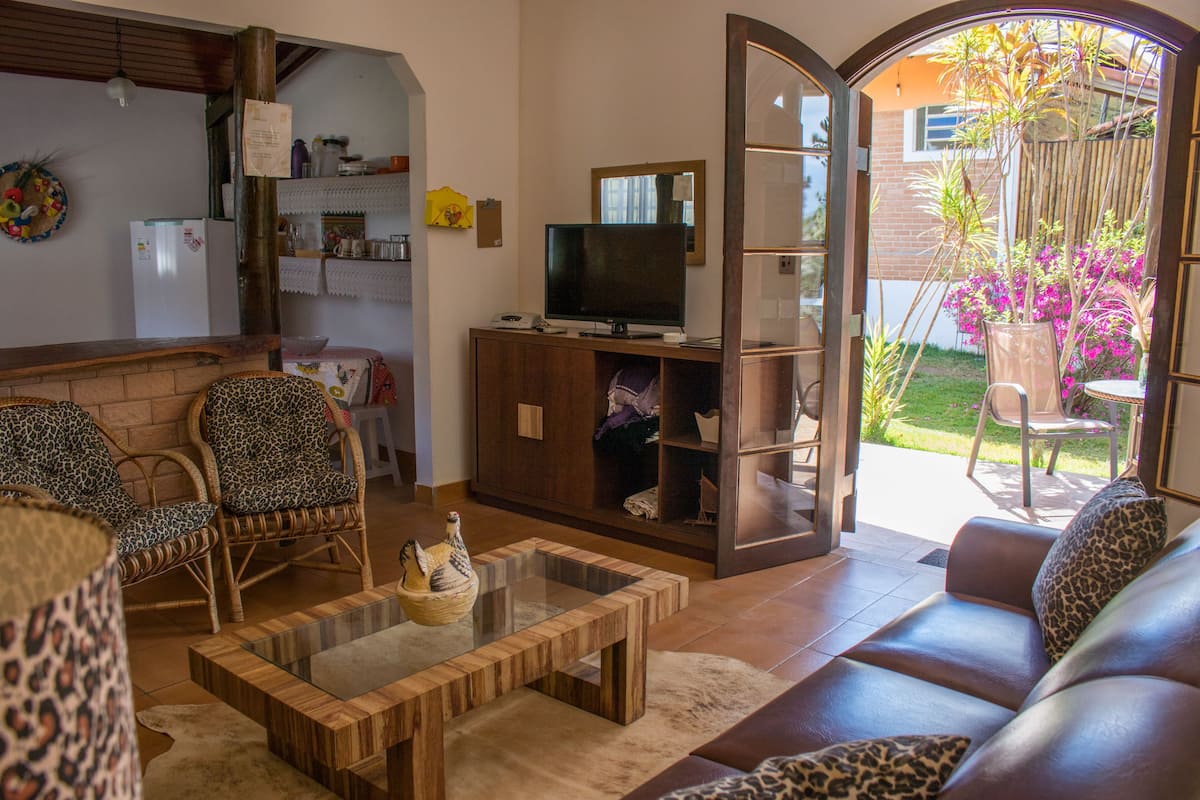 Una sala de estar con sofá, sillas, una mesa de centro y televisor.