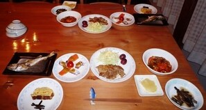 A wooden dining table with various dishes, chopsticks, and a teapot. - Lodge Suehiro (Yuzawa)