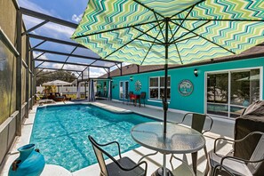 A swimming pool with a glass enclosure, a covered patio area, and outdoor seating. - Private Pool House, Near all Famous Attractions!!! (Kissimmee)