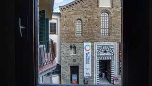 A view of a historic building with a stone facade, arched windows, and a balcony. - Art Apartment Luxury Ponte Vecchio Suite (Firenze)