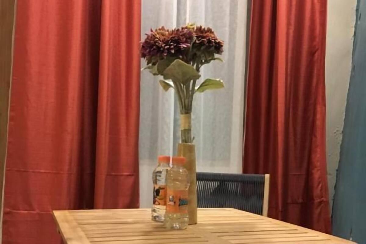 Una mesa de madera con un florero y dos botellas de agua.