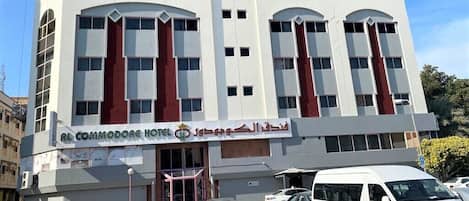 A hotel with a modern facade, multiple windows, and a visible entrance.