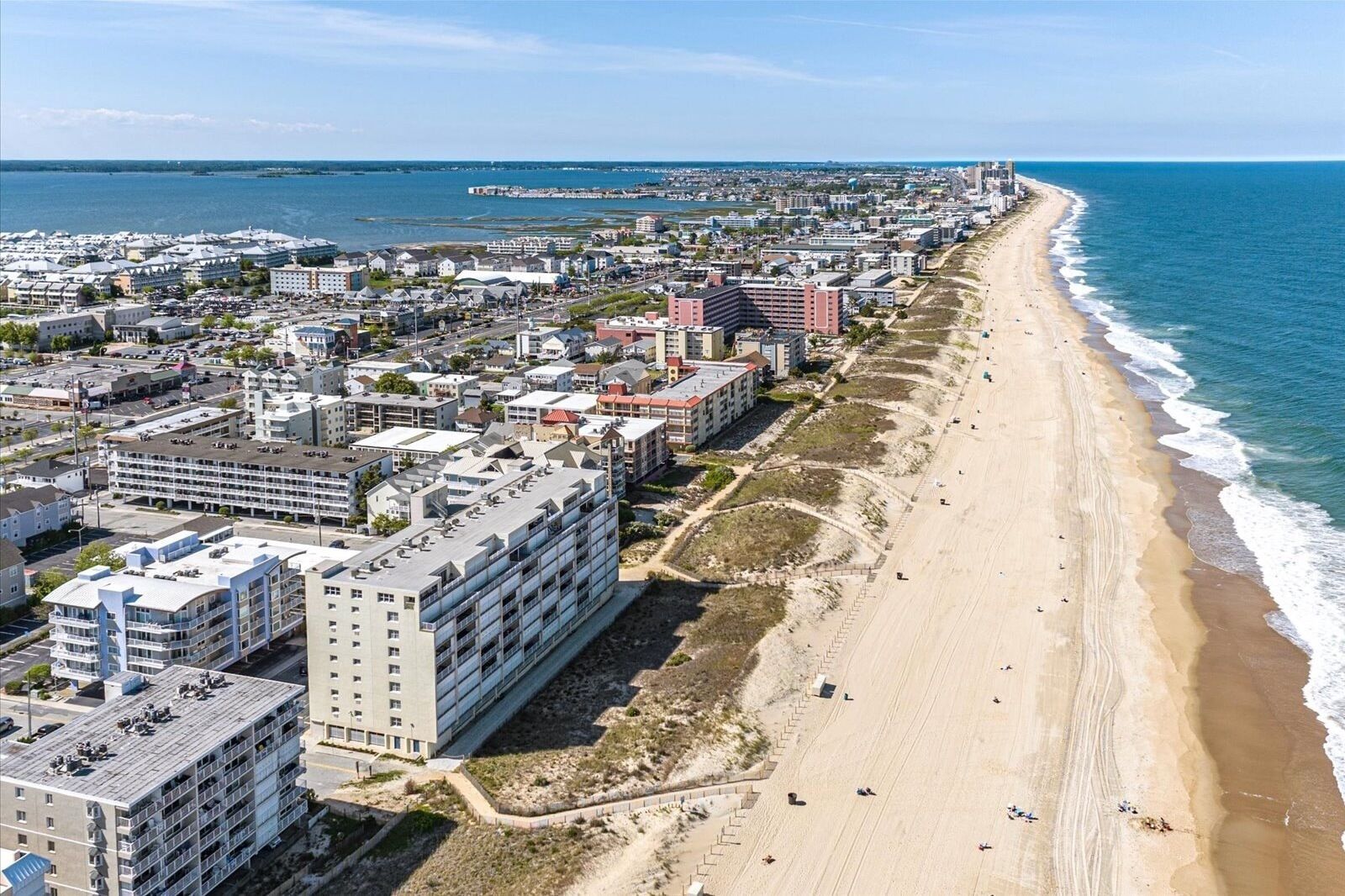 Eine Küstenstadt mit einem langen Strand, Hochhäusern und freiem Blick auf den Ozean.