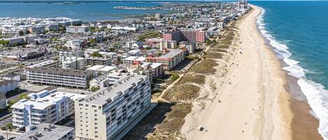 Eine Küstenstadt mit einem langen Strand, Hochhäusern und freiem Blick auf den Ozean.