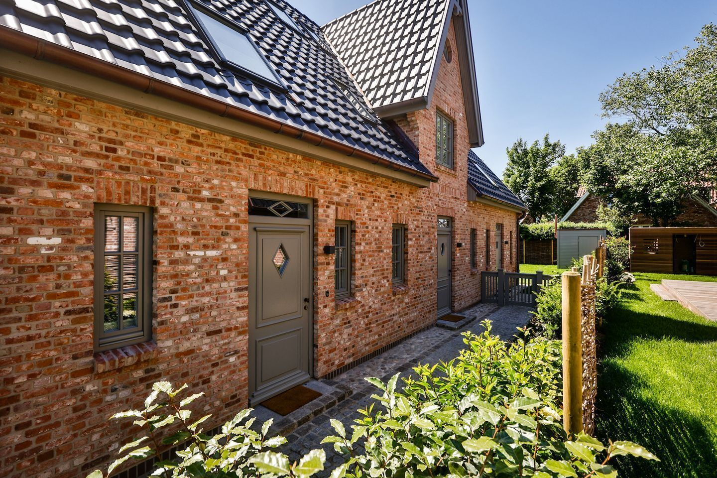 A brick house with a sloped roof, a front door, and a small porch.