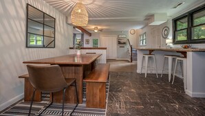 Una cocina amplia con una mesa de comedor de madera, taburetes de bar y una isla grande.