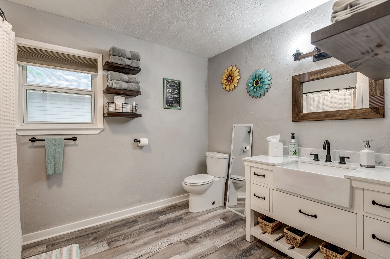 Een badkamer met toilet, wastafel en handdoekhouder.