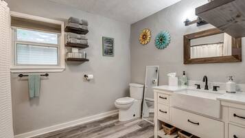 Een badkamer met toilet, wastafel en handdoekhouder.