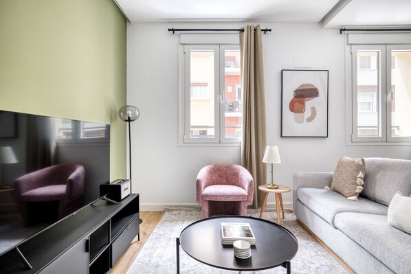 Relax in this stylish living room with a flat-screen TV, comfortable armchair, and cozy sofa.