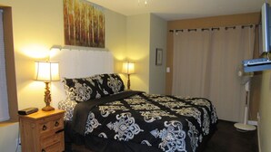 A bedroom with a bed, two bedside lamps, a dresser, a painting on the wall, and a window with blinds. - Super clean 2 bedroom/2 bath Walk to Sledding & Tubing located in Big Bear Lake (Big Bear Lake)