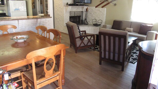 A spacious living area with a fireplace, a television mounted on the wall, and a pair of skis hanging above. - Super clean 2 bedroom/2 bath Walk to Sledding & Tubing located in Big Bear Lake (Big Bear Lake)