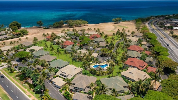 A coastal residential area with houses, a swimming pool, and a road. - New Owner Special! Ocean View in KoOlina, HI (Kapolei)