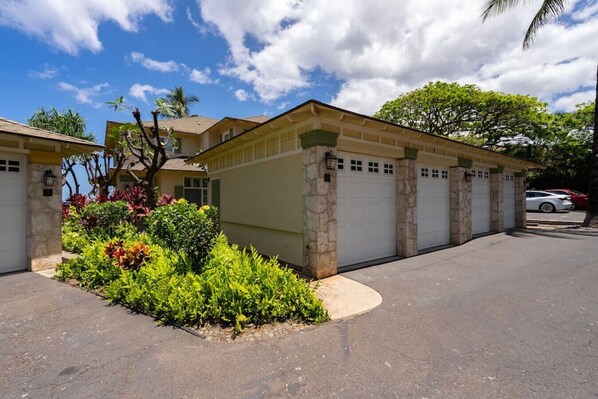 A residential property with a garage, a driveway, and a well-maintained garden. - Ocean View in KoOlina, HI, minutes from Milo Cove (Kapolei)
