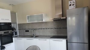 A modern kitchen with white cabinets, a stainless steel refrigerator, a microwave, and a sink. - Porto Vecchio villa with private heated pool near Saint Cyprien beach (Porto-Vecchio)