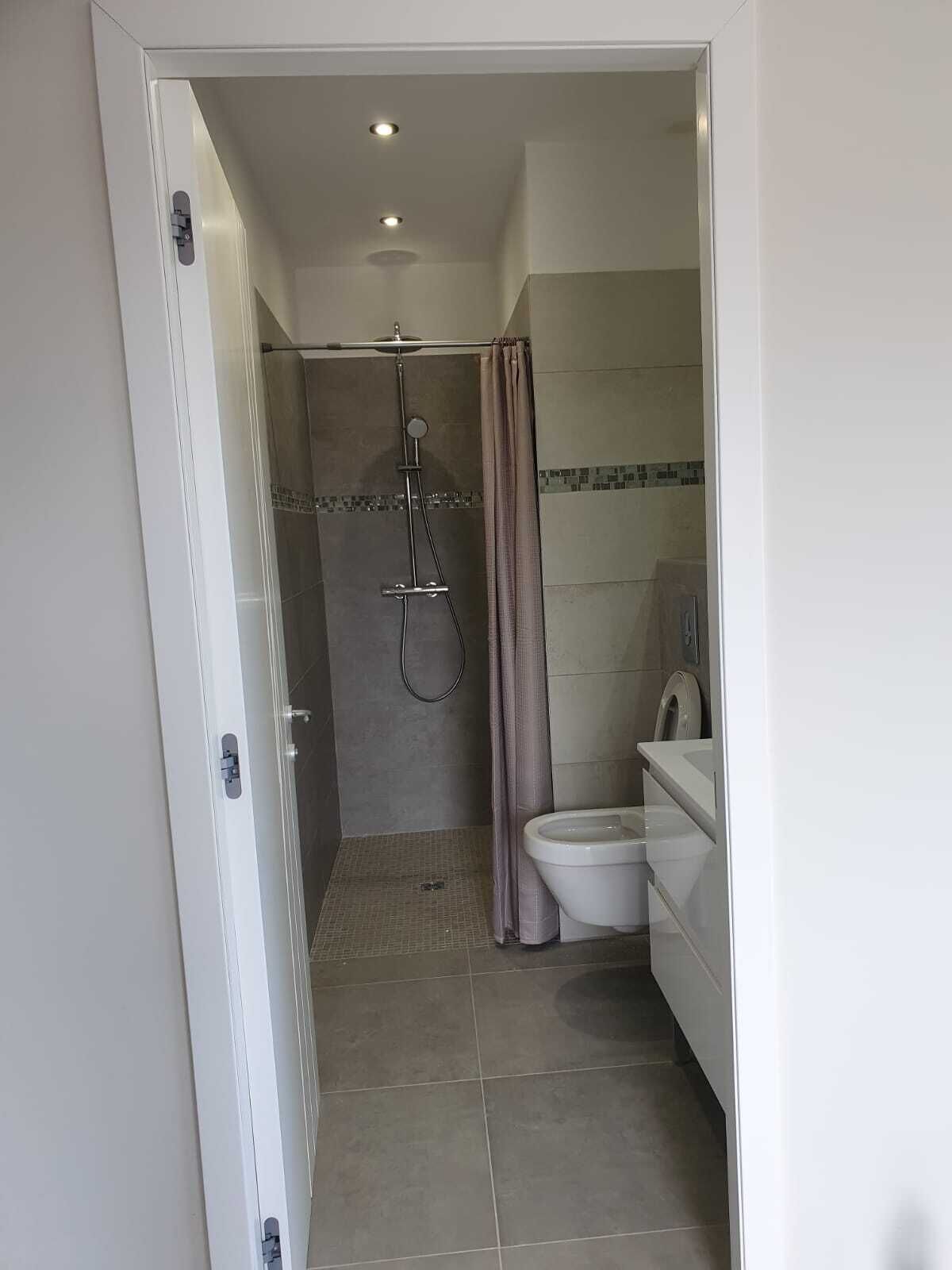 Ein Badezimmer mit Dusche, Toilette und Waschbecken.