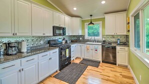 A kitchen with white cabinets, a stainless steel refrigerator, and a dishwasher.
