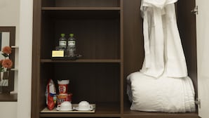 Un armario con estantes, una barra para colgar ropa y un refrigerador pequeño con una etiqueta.