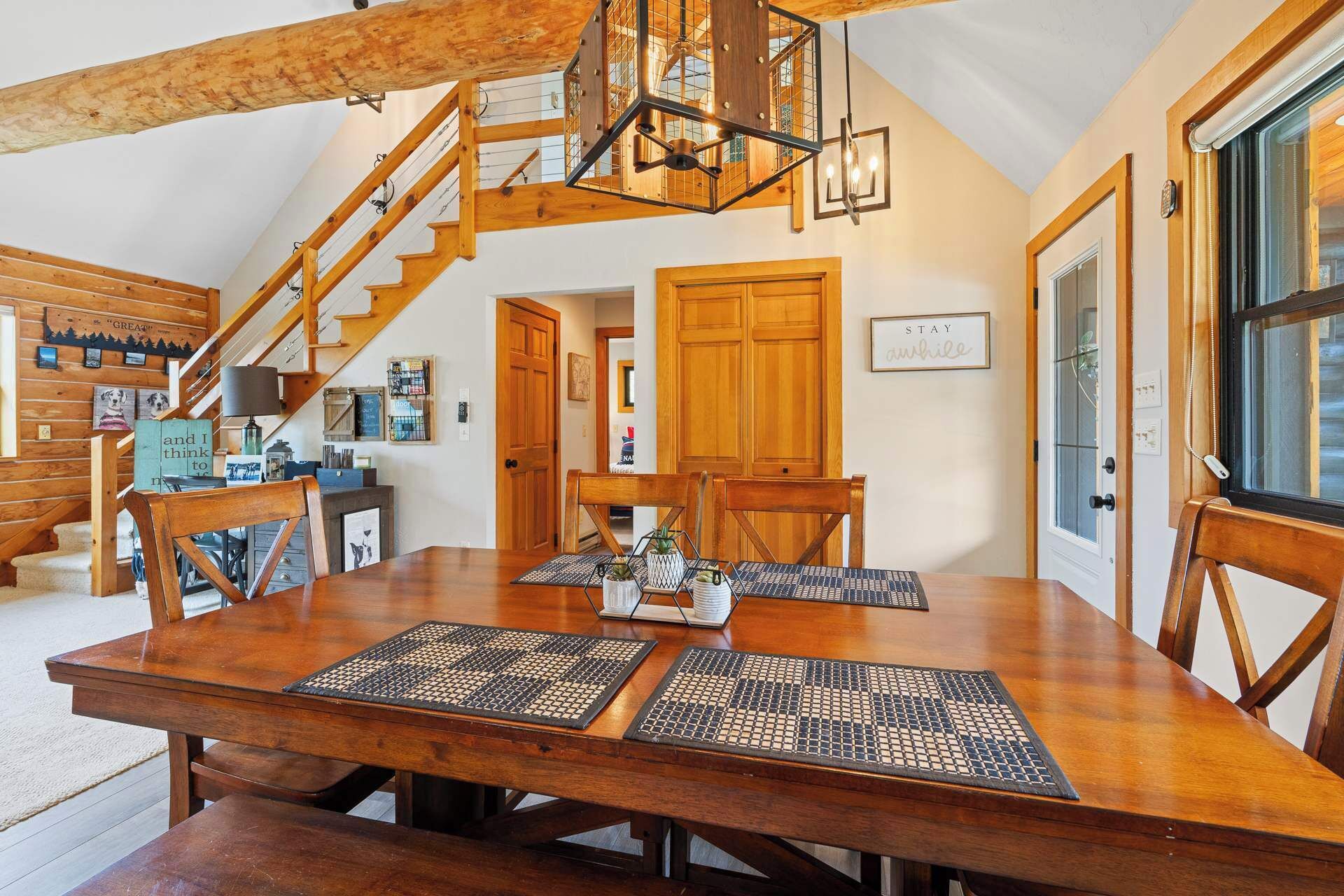 Ein geräumiger Essbereich mit einem großen Holztisch, mehreren Stühlen und einer Treppe, die zu einer oberen Ebene führt.