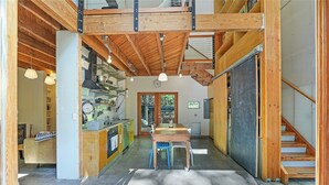 Una cucina moderna con travi in legno, un tavolo da pranzo e sedie.