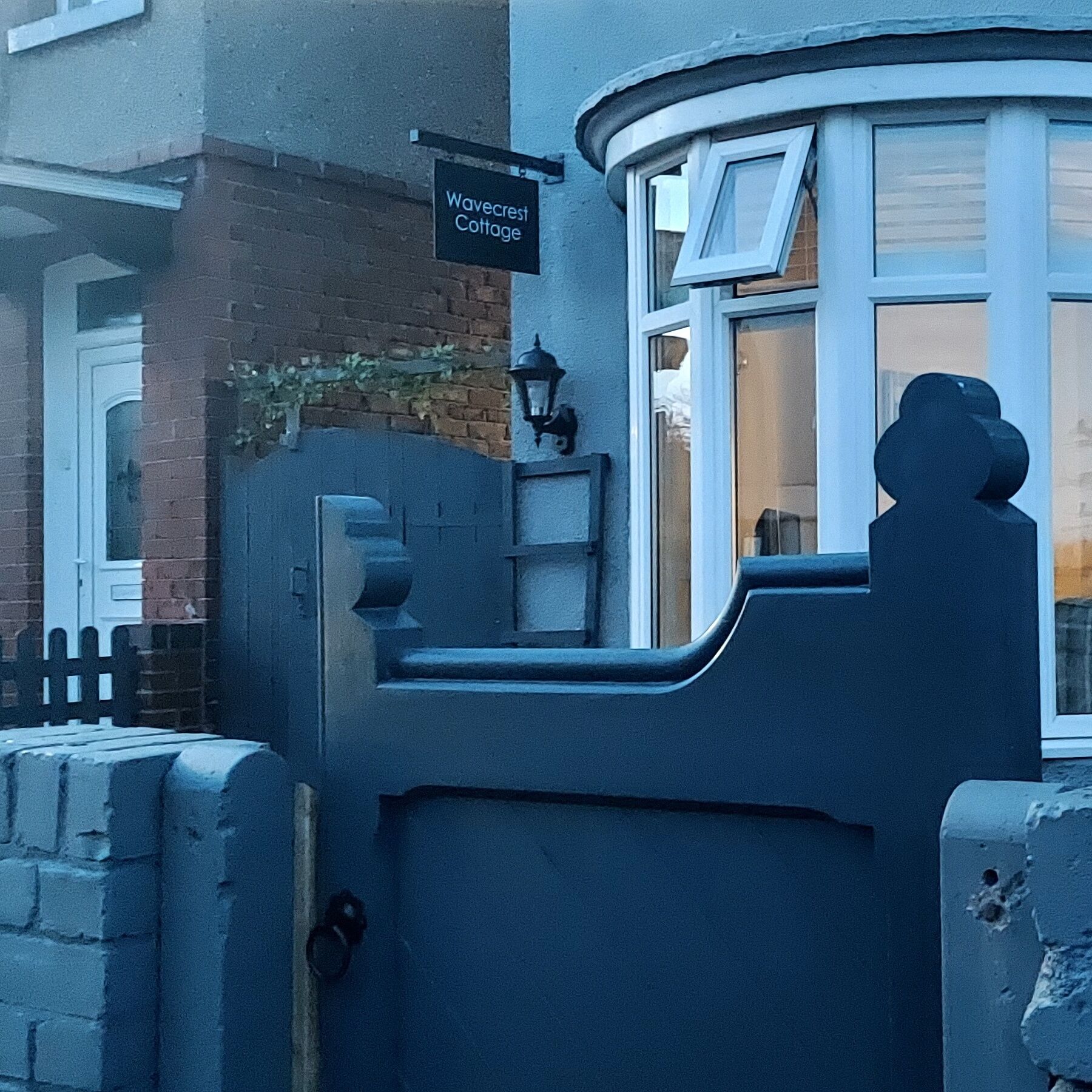 A corner of a building with a sign reading "Wavecrest Cottage".