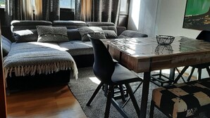 Ett modernt vardagsrum med en soffa, ett matbord och en stol.