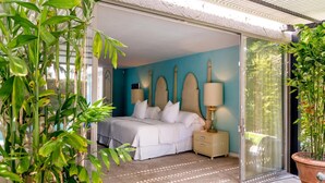 Ein Schlafzimmer mit einem Bett, Nachttischen und einer Schiebetür zum Balkon.