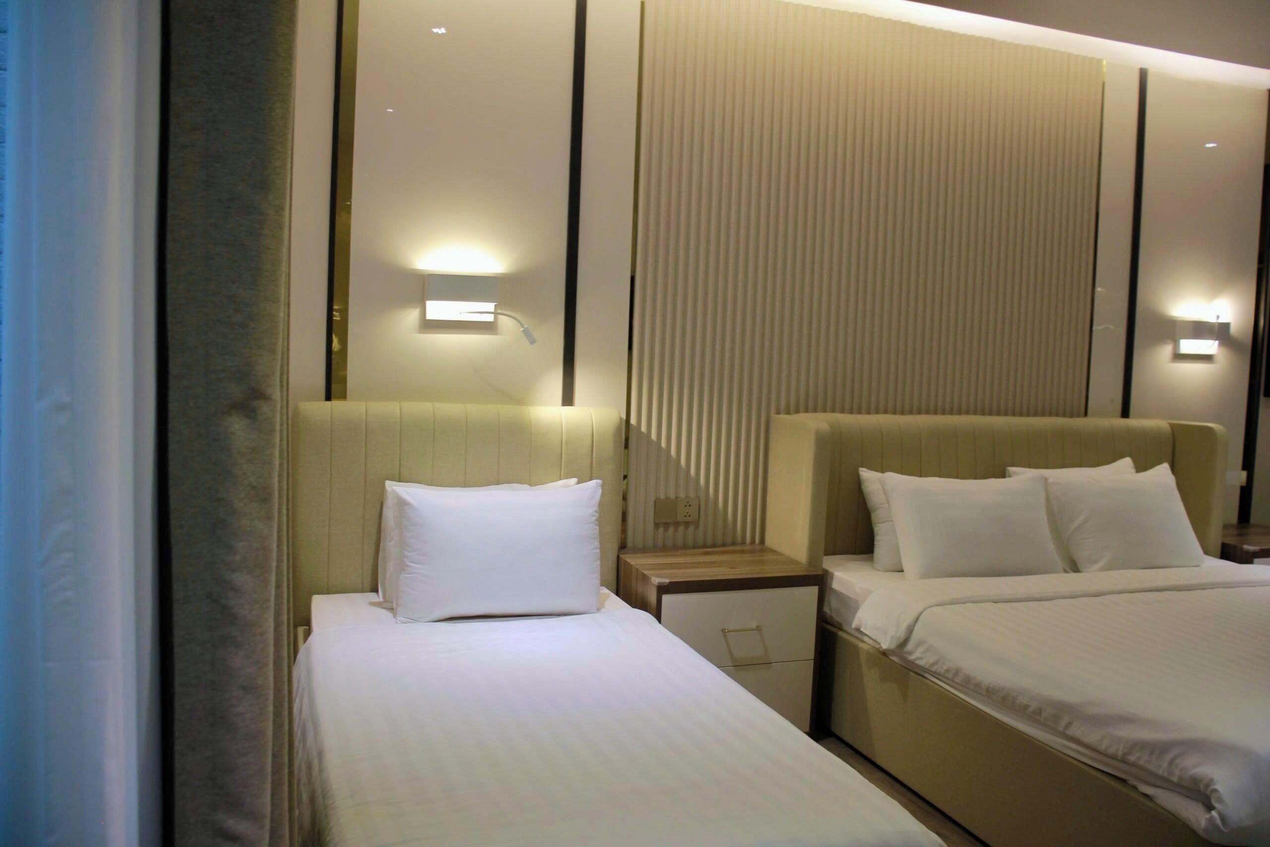 Ein Hotelzimmer mit Bett, Nachttischen und Wandleuchten.