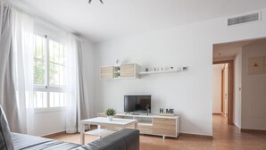 A modern living room with a sofa, TV, and a white console table. - High quality apartment 1 bedroom, 1 bathroom La Algaba (Algaba)