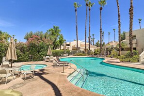 Relax by the clear blue pool surrounded by palm trees and lush greenery.
