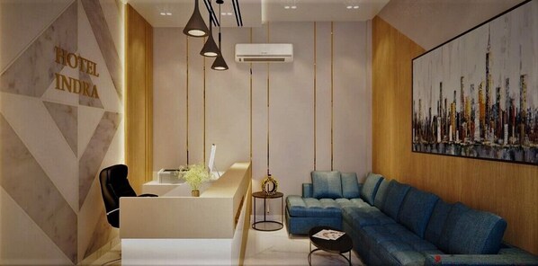 A modern hotel lobby with a reception desk, seating area, and a large cityscape painting. - Hotel Indra (Jaunpur)