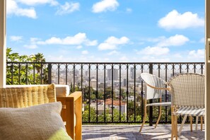 A balcony with wicker furniture and a view of a cityscape. - Voted Guest Favorite! Walk Hollywood Bowl (Los Angeles)