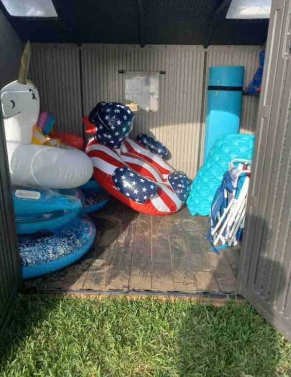 A storage area with inflatable pools and a blue barrel. - Remodeled Lakefront! Private beach, toys & hot tub (Little Elm)