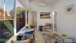 Ein modernes Wohnzimmer mit Essbereich, großen Fenstern und Blick ins Freie.