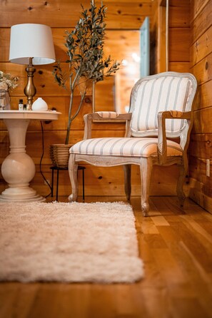 Relax in this inviting space with a classic armchair, round table, and potted plant.