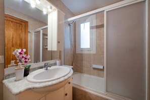 Tina con regadera, secadora de cabello, bidet, toallas 